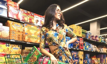 Mujer en el supermercado leyendo etiquetas de los alimentos entre productos ultraprocesados