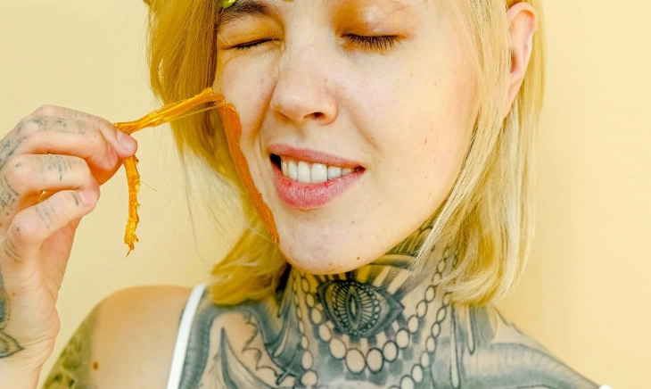 mujer con mascarilla facial y tatuajes como símbolo de autocuidado y libertad personal