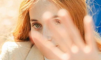 Mujer con piel sensible protegiéndose del sol y el exceso de estímulos