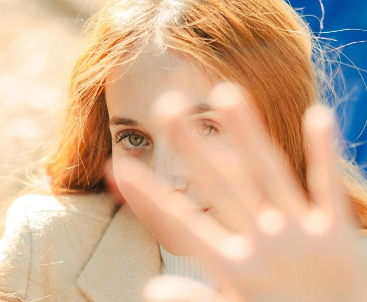 piel sensible Mujer con piel sensible protegiéndose del sol y el exceso de estímulos
