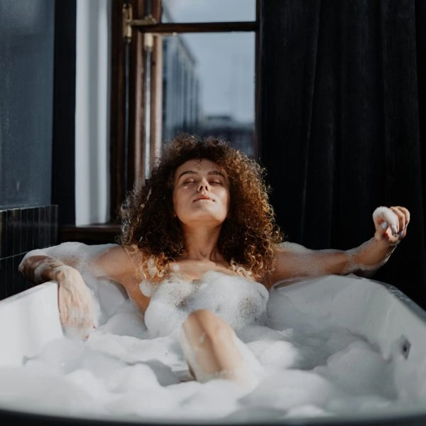 Mujer sumergida en una bañera con sales de Epsom, el ritual inglés que vuelve por sus beneficios relajantes