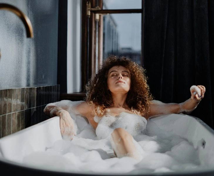 Mujer sumergida en una bañera con sales de Epsom, el ritual inglés que vuelve por sus beneficios relajantes
