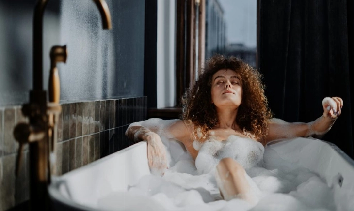 Mujer sumergida en una bañera con sales de Epsom, el ritual inglés que vuelve por sus beneficios relajantes