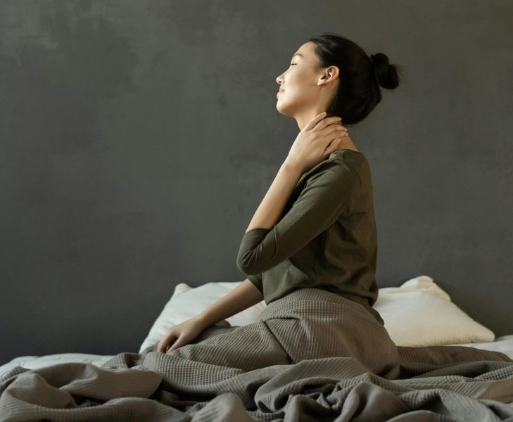 Mujer despierta con cansancio en la cama, reflejando cómo dormir poco aumenta el riesgo cardiovascular y acelera el envejecimiento del cuerpo