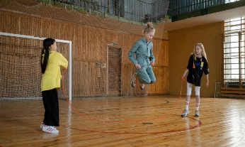 Tres niñas jugando a la comba en el gimnasio, ejemplo de juego libre infantil que estimula la creatividad y la coordinación