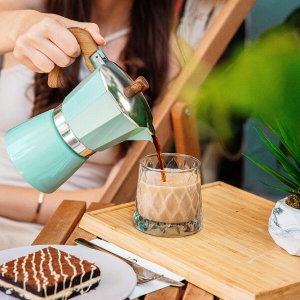 Mujer sirviendo café junto a un bollito con chocolate, ejemplo de hábitos poco convencionales que estimulan los postbióticos