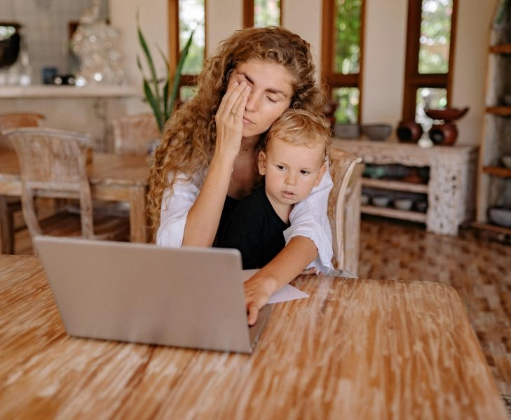 eliminar el estrés mujer cansada intenta eliminar el estrés mientras trabaja con su hijo pequeño en brazos