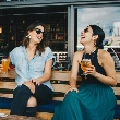 Mujeres toman cervezas como flourishing