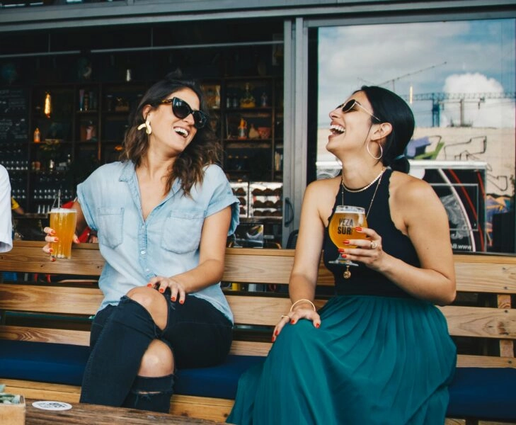 Mujeres toman cervezas como flourishing