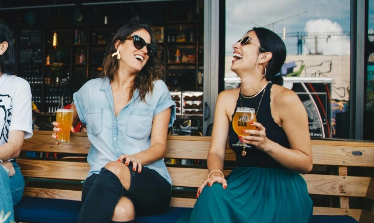 Mujeres toman cervezas como flourishing