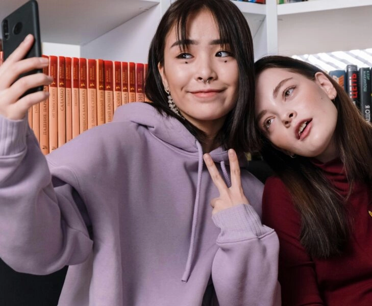 Dos jóvenes haciéndose un selfie, representando la imagen idealizada que se proyecta en redes sociales