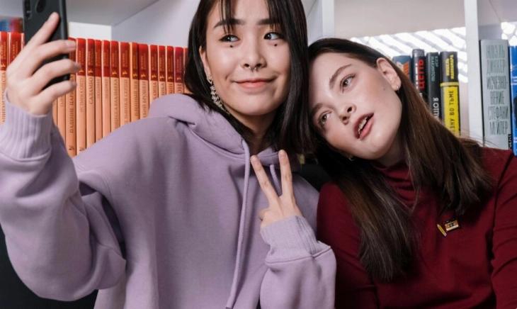 Dos jóvenes haciéndose un selfie, representando la imagen idealizada que se proyecta en redes sociales