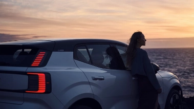 Mujer cerca de un coche, reduciendo ansiedad al volante