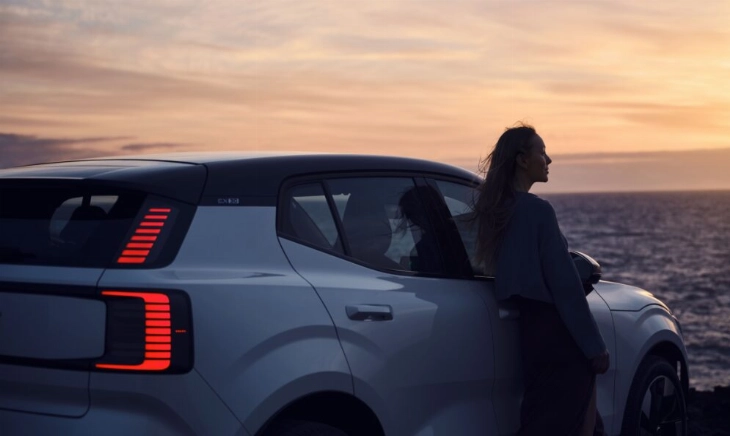 Mujer cerca de un coche, reduciendo ansiedad al volante