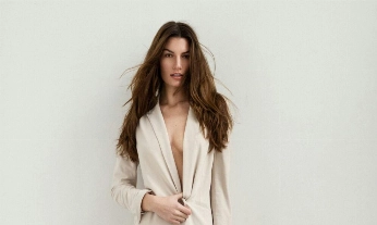 Mujer posando con un look minimalista, evocando los cánones estéticos que influyen en la relación femenina con la alimentación