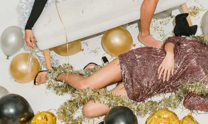 Dos invitadas agotadas entre globos y serpentinas tras una fiesta, una escena que invita a pensar en alternativas como los cócteles de Navidad sin alcohol.