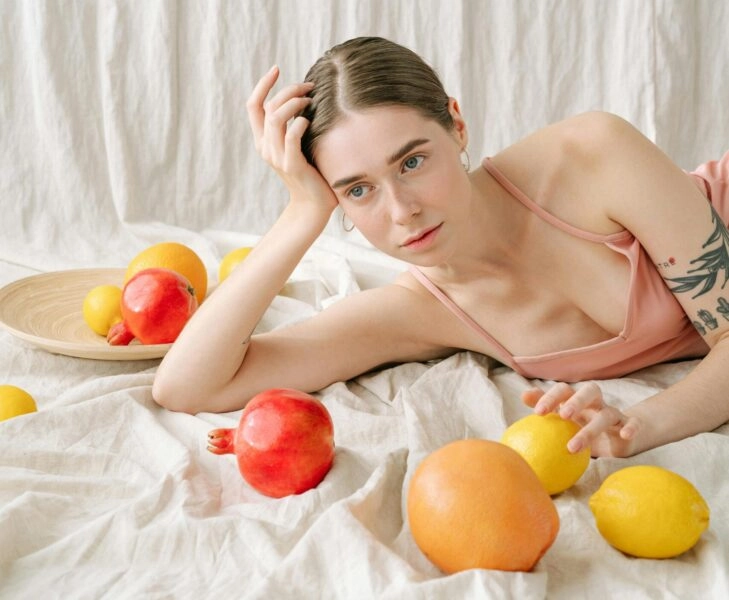 Mujer con frutas que son ingredientes comestibles para cosméticos