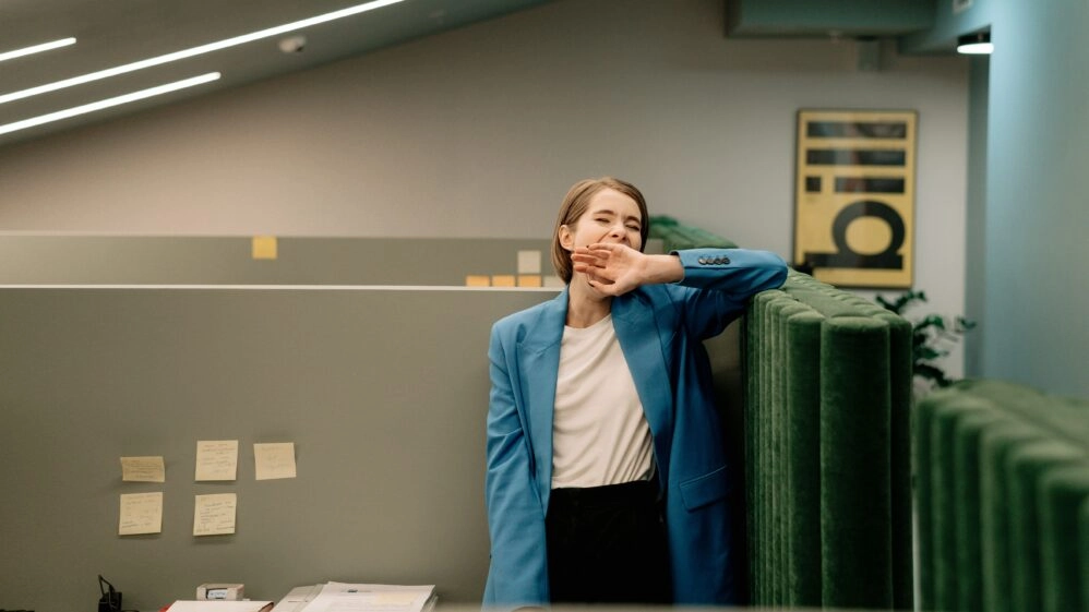 Mujer en la oficina bostezando como imagen de alguien que no ha superado el jet lag