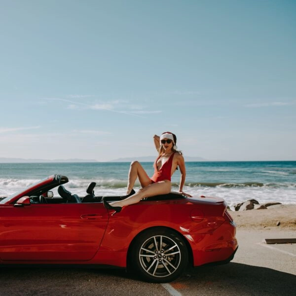 Mujer con ropa navideña en una playa, una imagen que representa la idea de alargar las vacaciones y el debate sobre cuánto tiempo necesita el cuerpo para descansar.