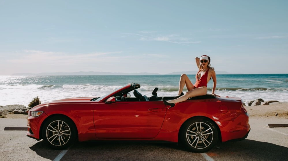 Mujer con ropa navideña en una playa, una imagen que representa la idea de alargar las vacaciones y el debate sobre cuánto tiempo necesita el cuerpo para descansar.