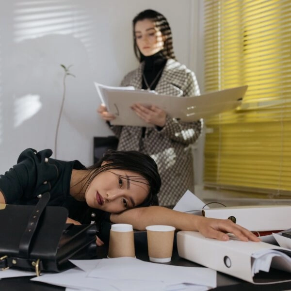 Mujer agotada tras trabajar más horas de las necesarias para demostrar su valía profesional tras un ascenso
