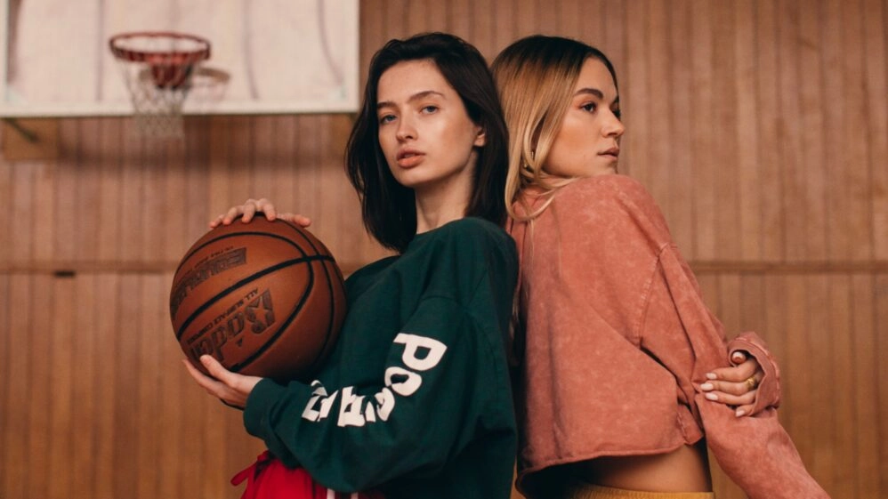 Dos chicas en una cancha de baloncesto preguntándose qué deporte aporta una mayor longevidad